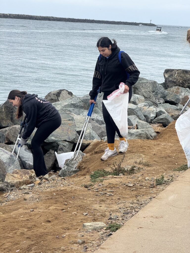 Students cleaning up a rocky shoreline — Black Tech Link BIPOC Coastal Research Program (BCRP)