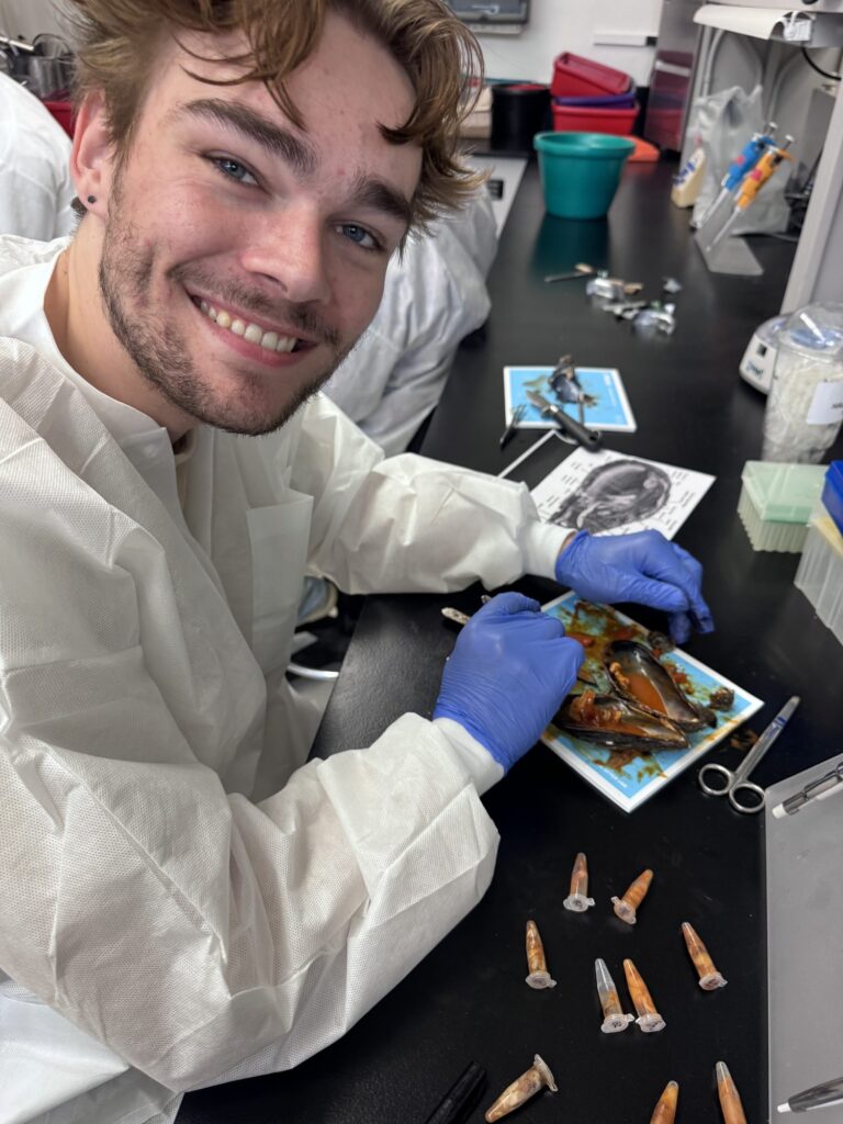 Student in a lab coat with specimens on a tray — Black Tech Link BIPOC Coastal Research Program (BCRP)